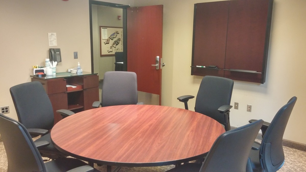 Single breakout room featuring a round table and six executive chairs.